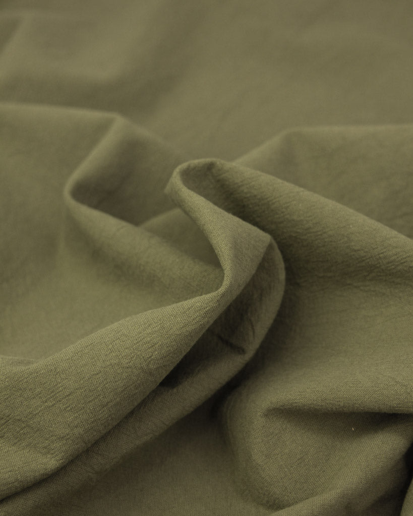 Close up of washed cotton fabric in a soft green colour