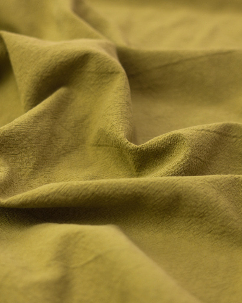 Crushed washed cotton fabric in yellow olive green