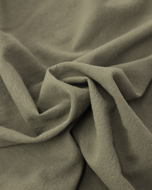 Close up of crushed washed cotton fabric in a soft grey-green