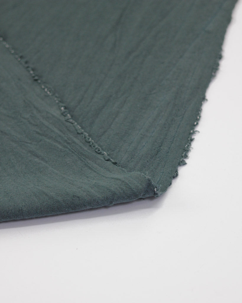 Flipped edge of crushed washed cotton fabric in slate grey