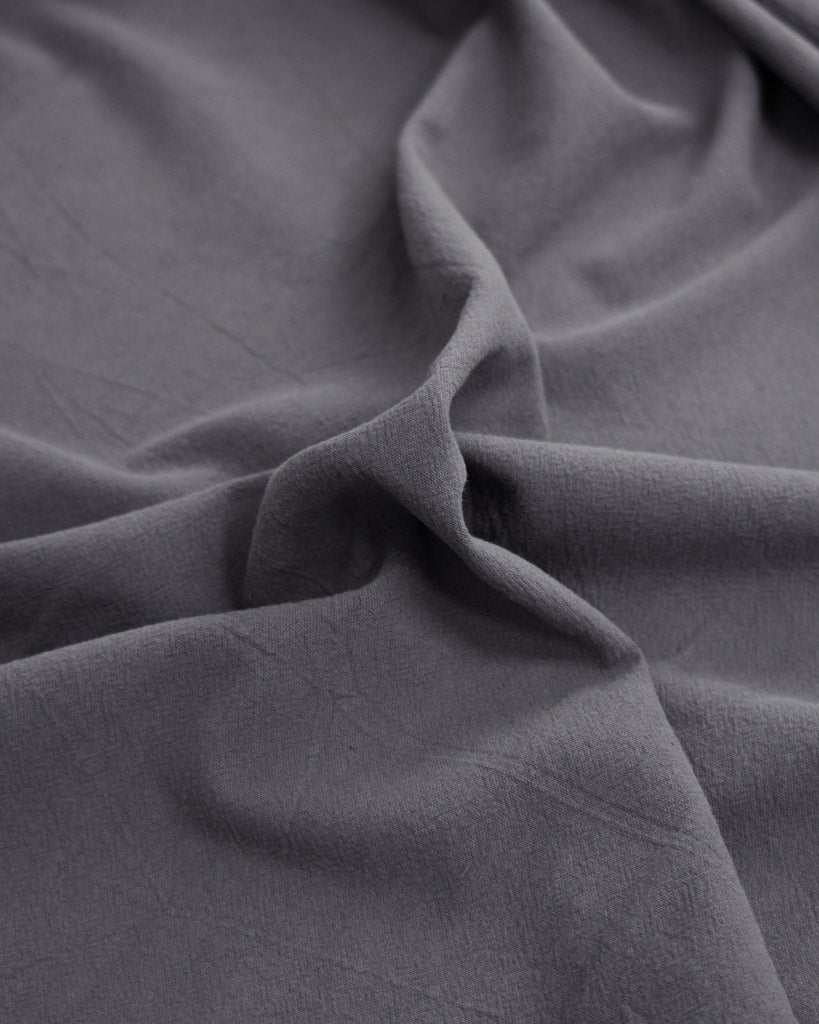 Close up of crushed washed cotton fabric in dark grey
