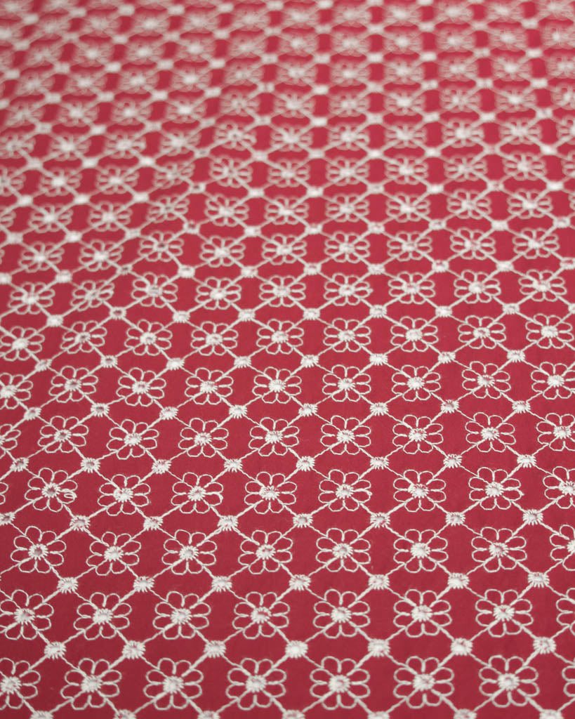 Red cotton broderie anglais fabric with white floral eyelet embroidery
