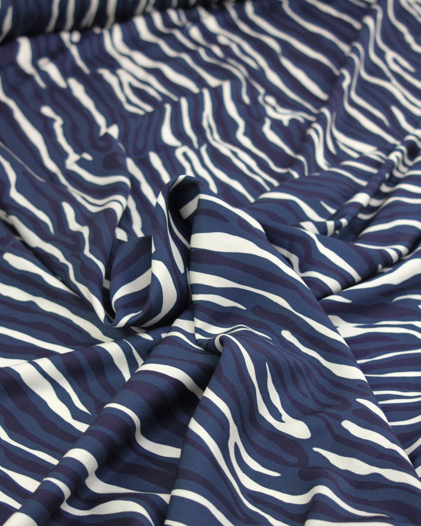 Drapey viscose twill fabric with irregular navy blue and white line stripes