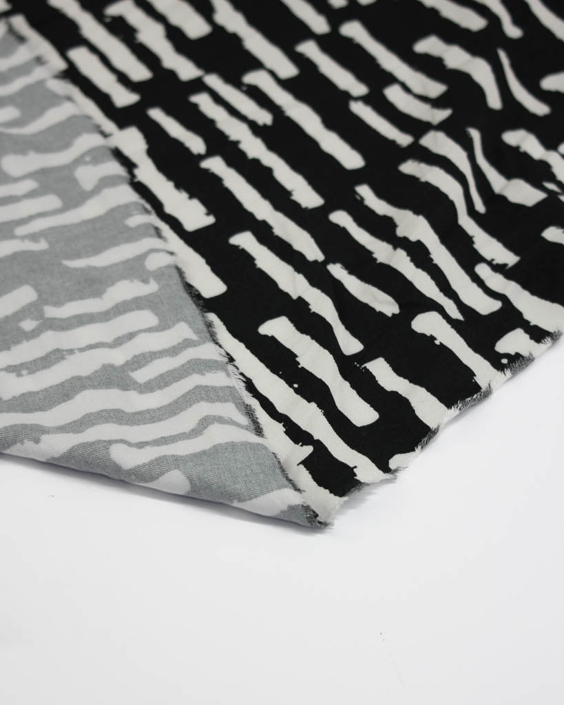 Viscose twill fabric with black and white abstract patterns on a white background