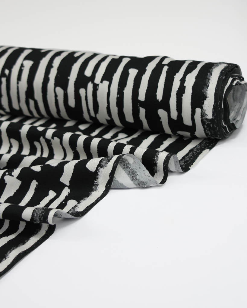 Black and white striped viscose twill fabric on a white background