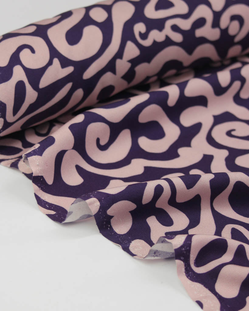 Purple and pink patterned viscose twill fabric on a white background