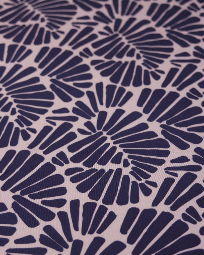 Viscose twill fabric featuring an all-over palm fan motif in deep, rich purple on a soft dusty mauve ground