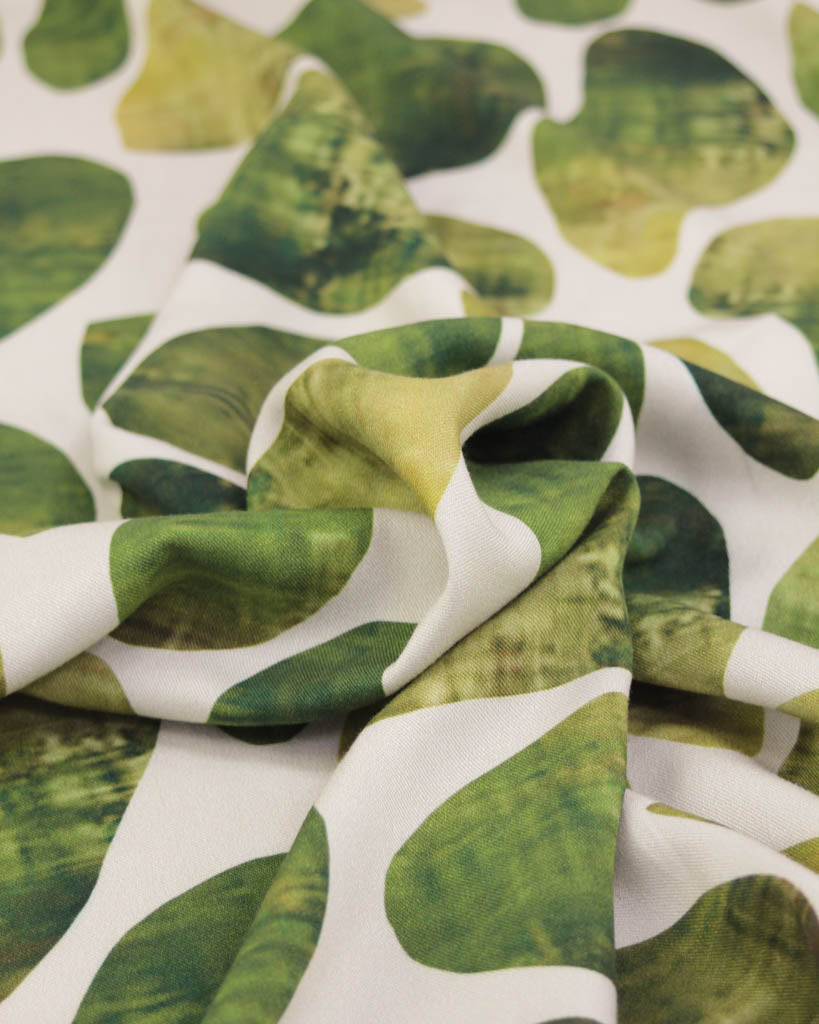 Green leaf pattern viscose twill fabric on a white background