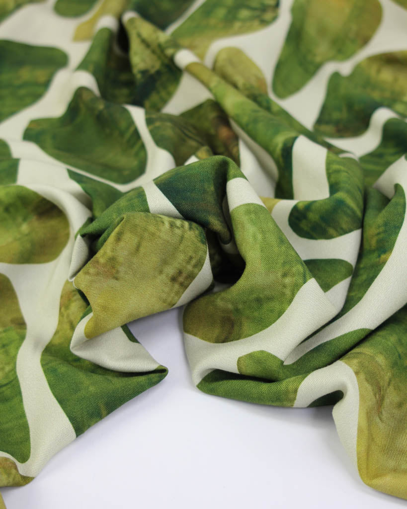 Green and white green oval patterned viscose twill fabric on a white background