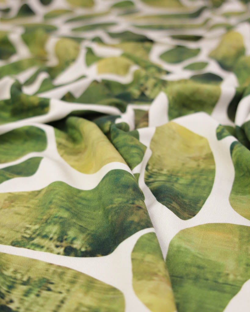 Close-up of green and white oval patterned viscose twill fabric