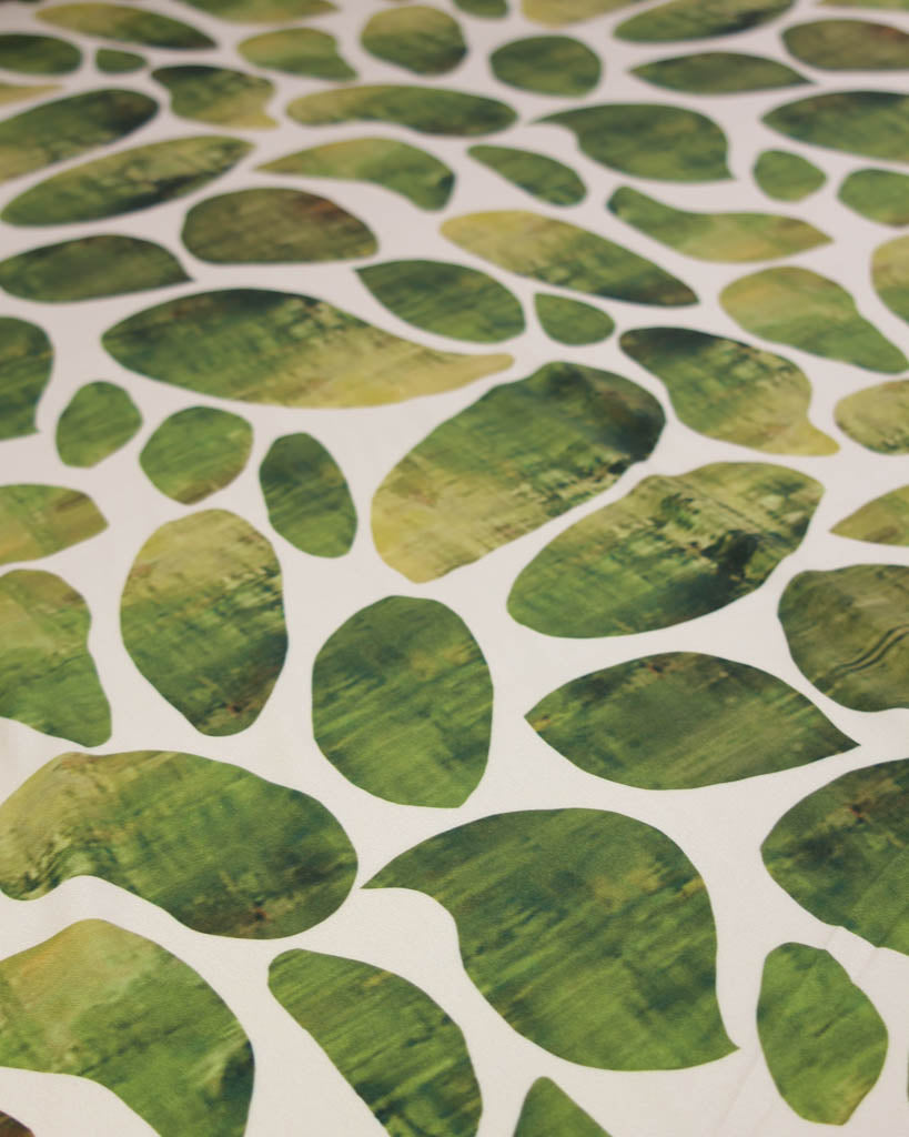 Pattern of green leaf shapes on a beige background viscose twill fabric