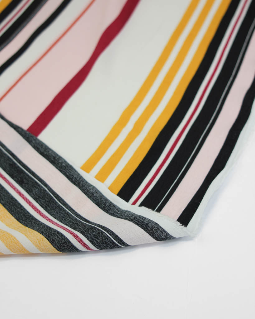 Close-up of viscose crepe fabric with multicolored stripes on a white background