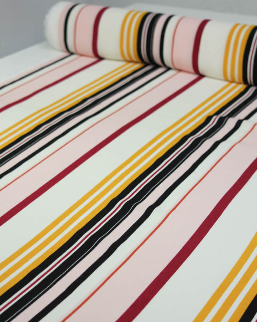 Roll of viscose crepe fabric with multicolored stripes on a white background