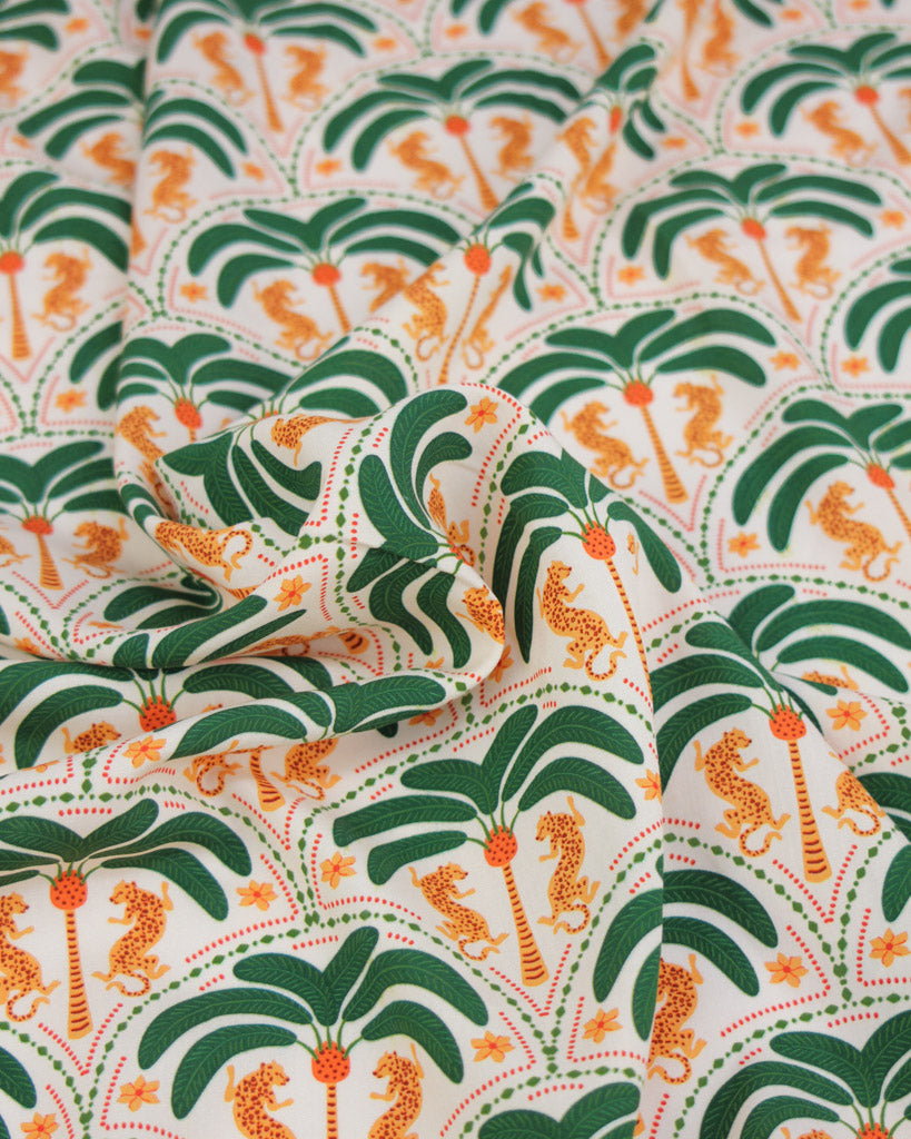 Viscose fabric with a pattern of palm trees and leopards on a white background