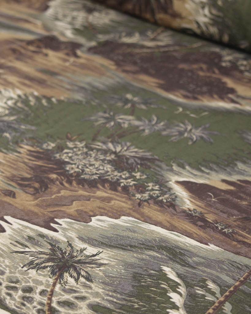 Close-up of a fabric with tropical pattern featuring palm trees and plants.