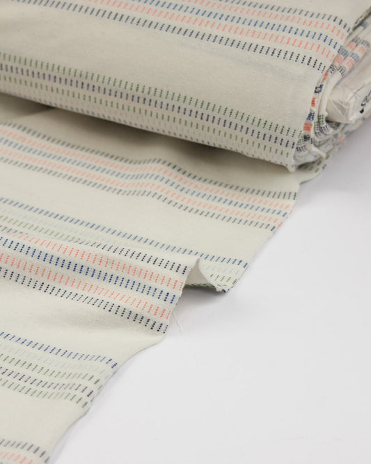 Close-up of striped cotton jersey fabric with a neutral color palette on a white background