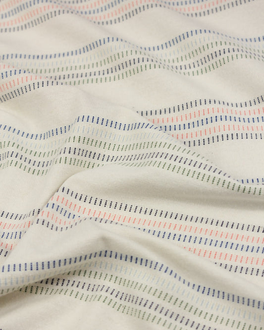 Close-up of cotton jersey fabric in cream with a stripe design