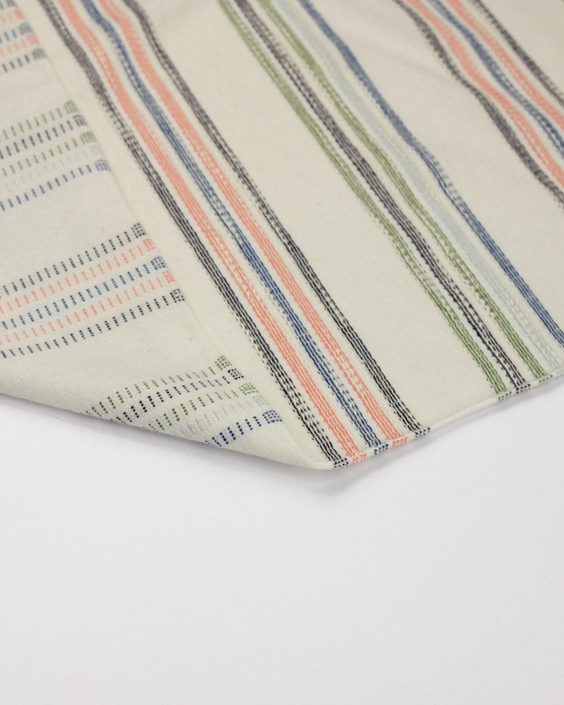 Close-up of striped cotton jersey fabric with multicolor pattern on a white background