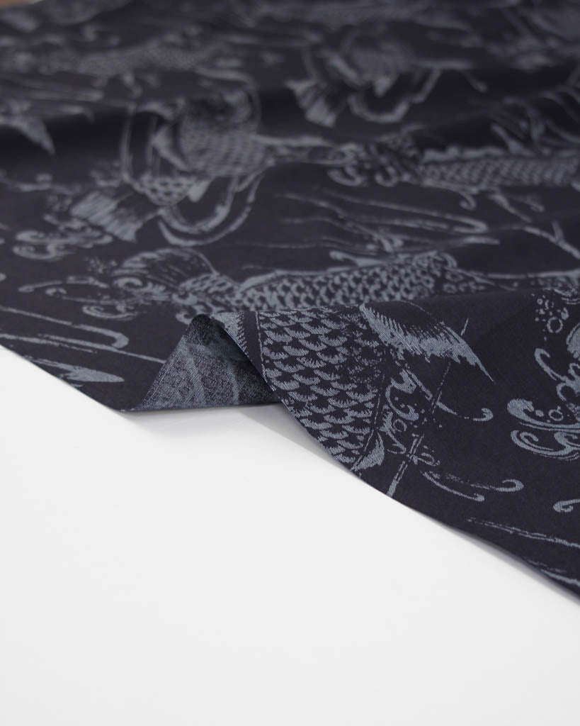 Close-up of dark blue linen cotton fabric with koi fish design