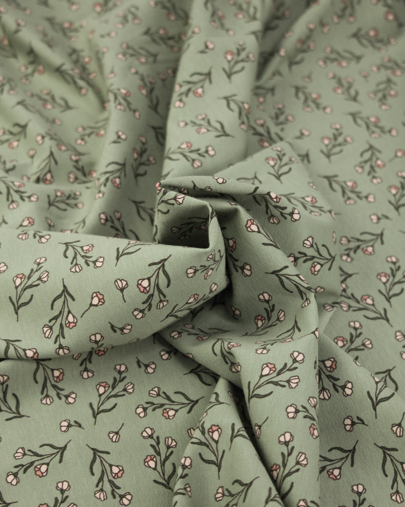 Green jersey knit fabric with small floral pattern