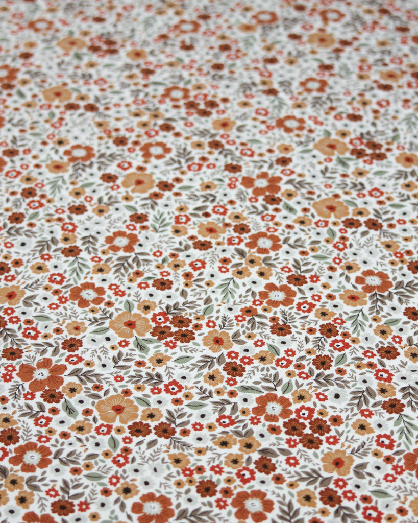 Floral patterned fabric with small flowers in various colours on a white background