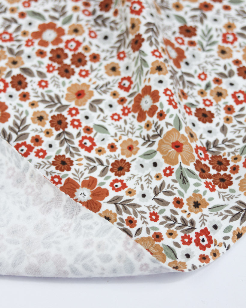 Floral patterned jersey fabric with a bronze ditsy floral print
