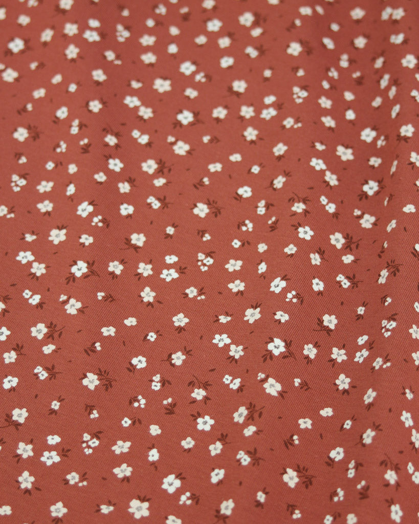 Red cotton jersey fabric with small white floral pattern