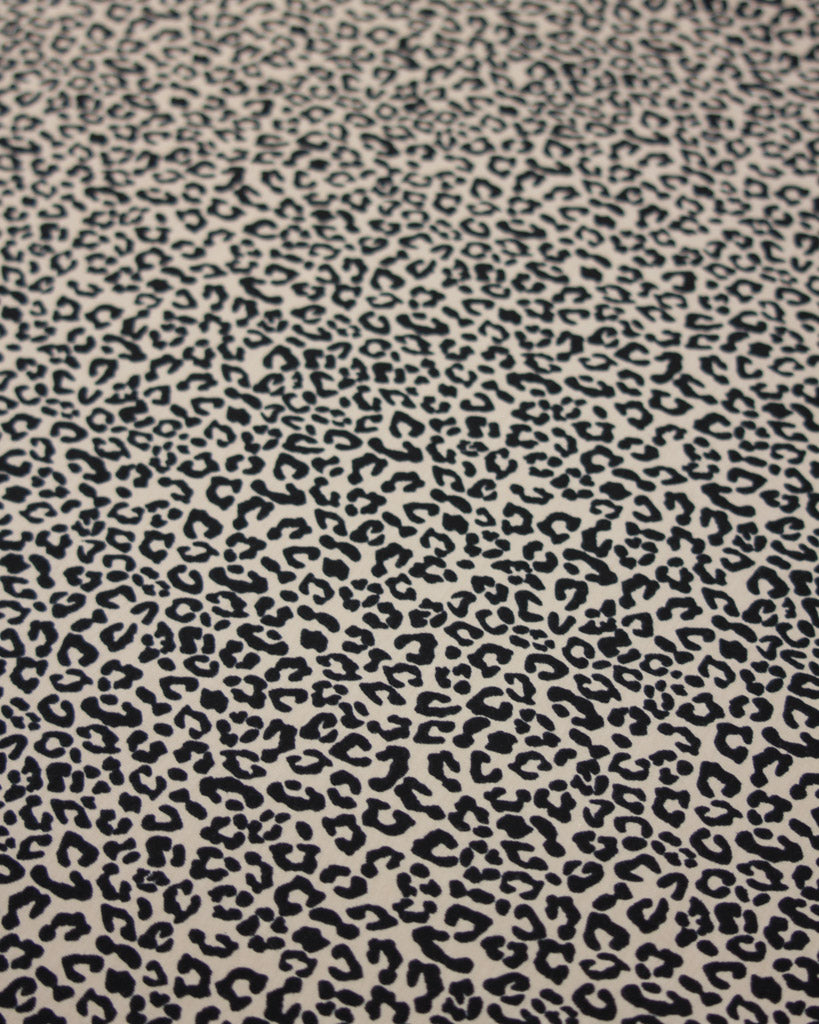 Small scale leopard print pattern on a beige background on a soft cotton jersey fabric