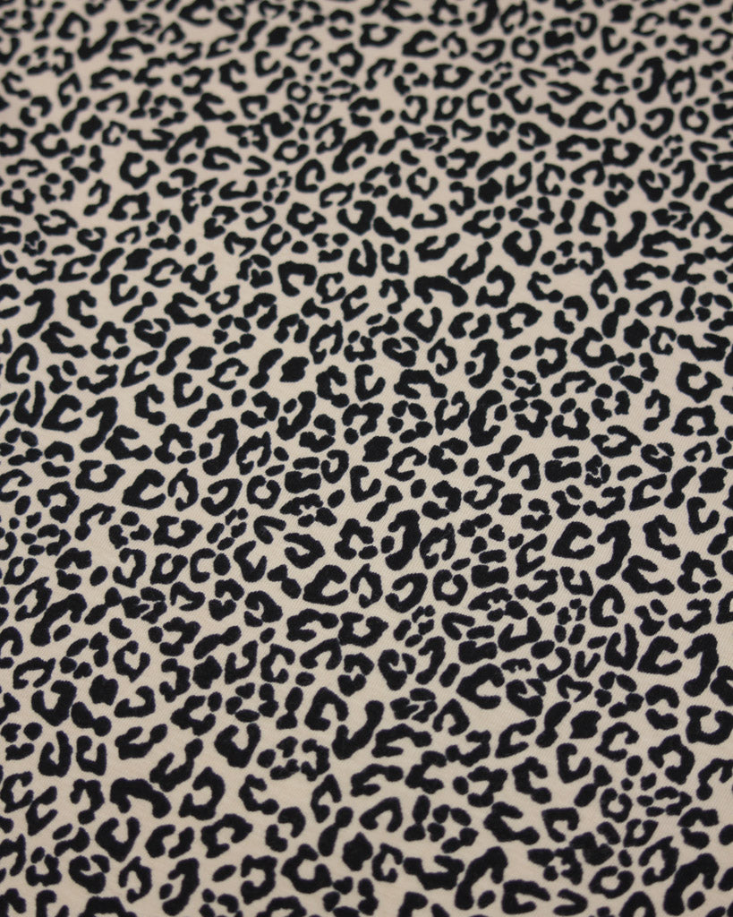 Leopard print pattern on a beige background on a soft cotton jersey fabric
