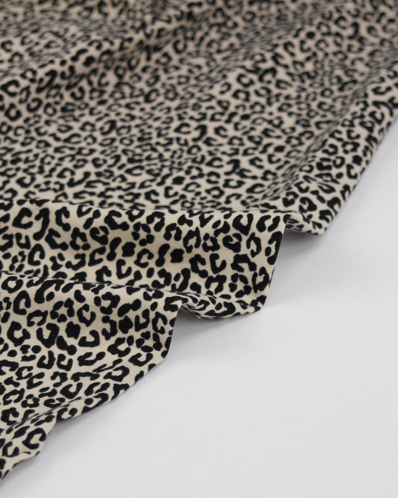 Leopard print cotton jersey fabric in beige on a white background