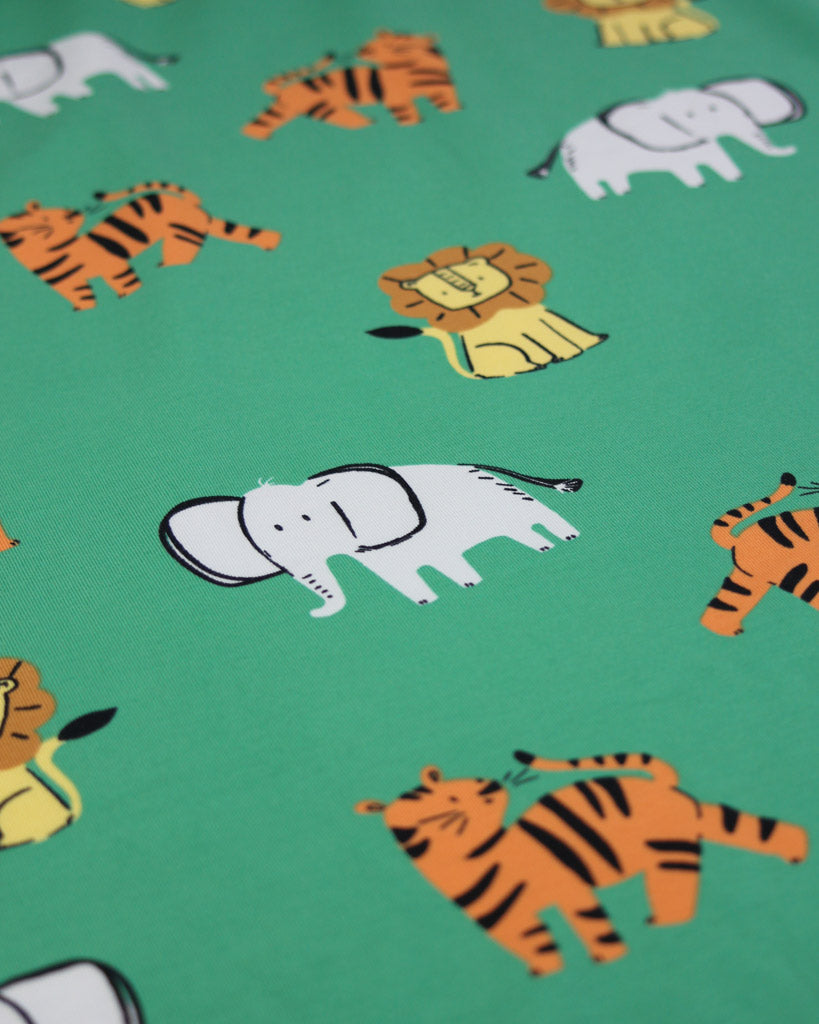 Pattern of cartoon animals, tigers, lions and elephants, on a green background on cotton jersey fabric 