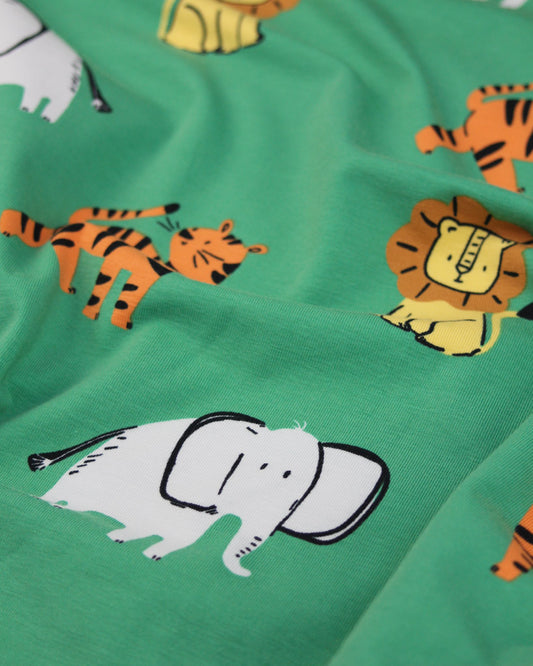 Green cotton jersey fabric with cartoon tigers and elephants on a green background