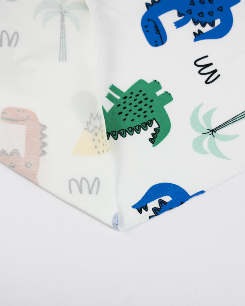 Children's cotton jersey fabric with dinosaur prints on a white background
