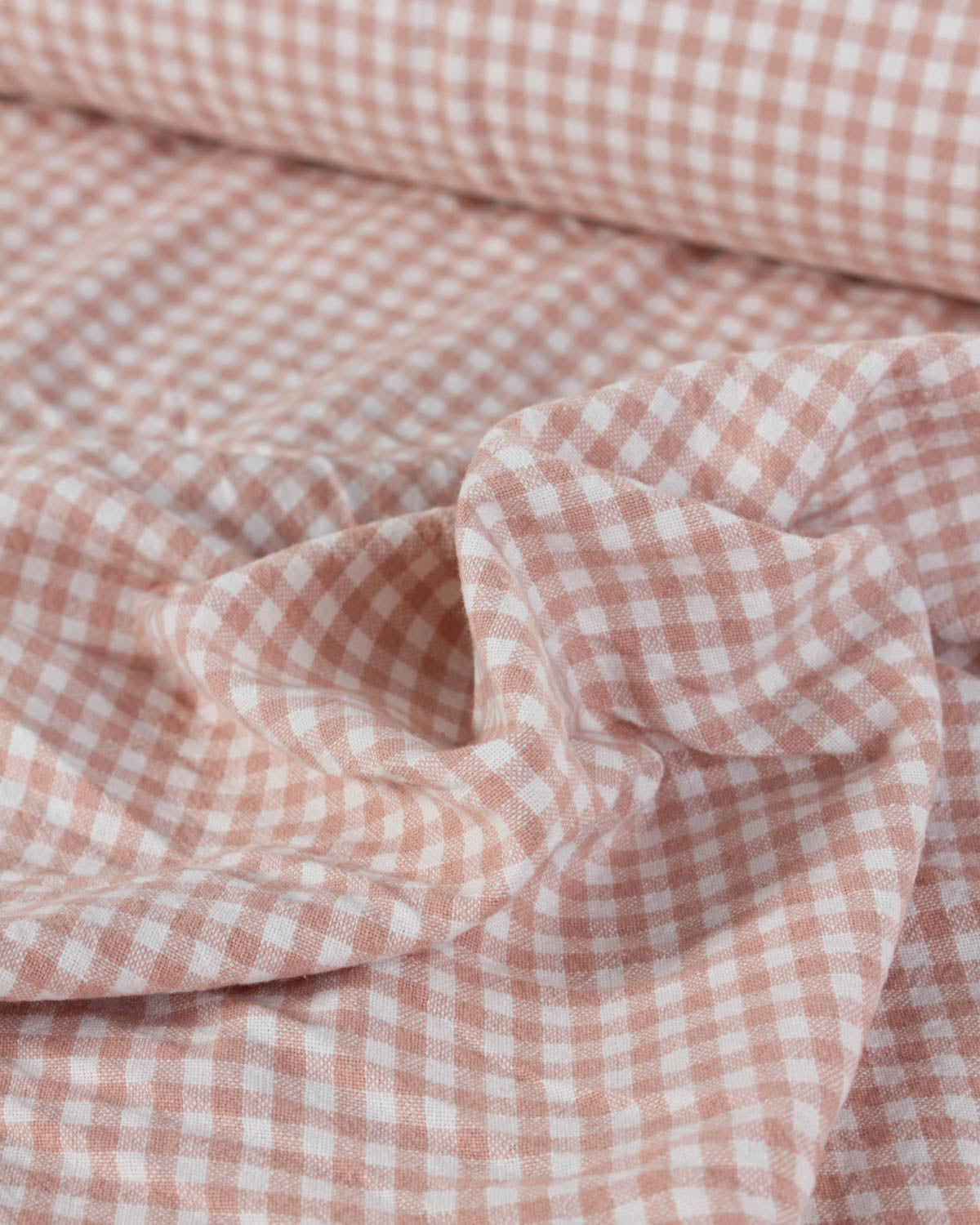 Close-up of pink and white checkered gingham organic cotton fabric