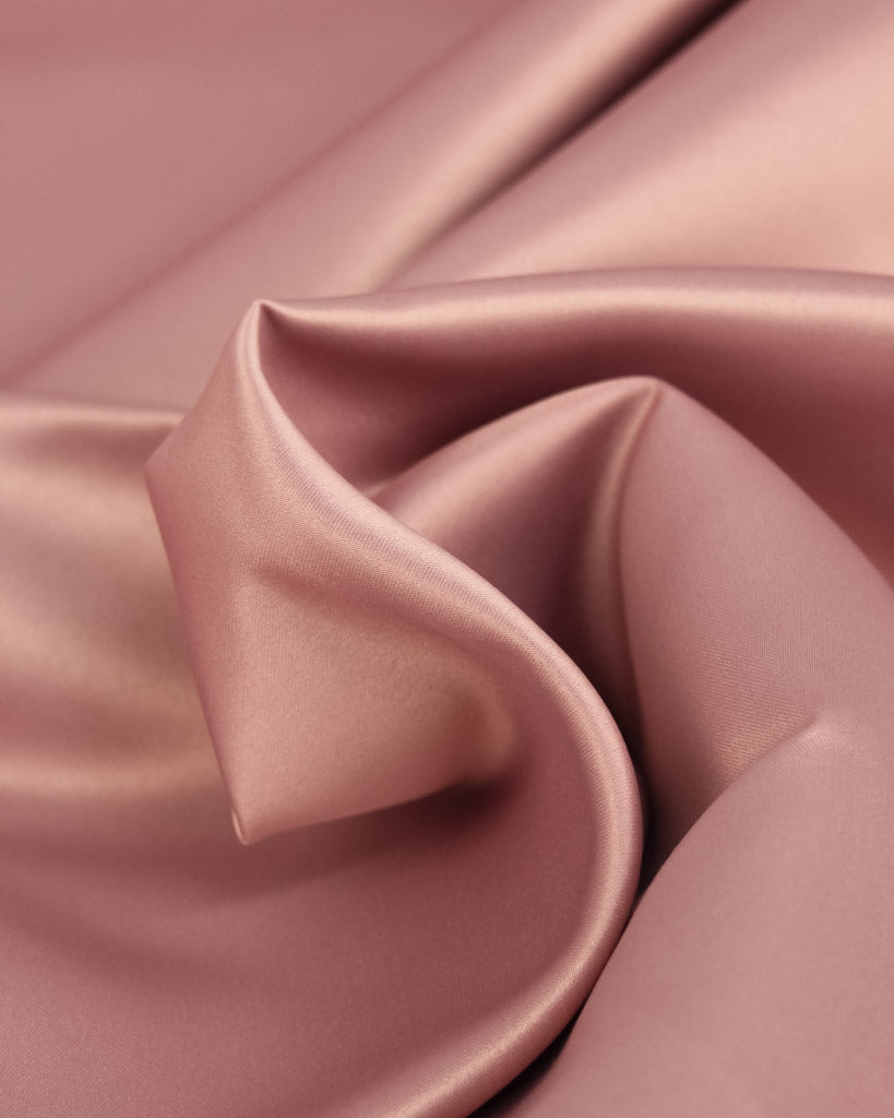 Close-up of pink satin fabric with folds