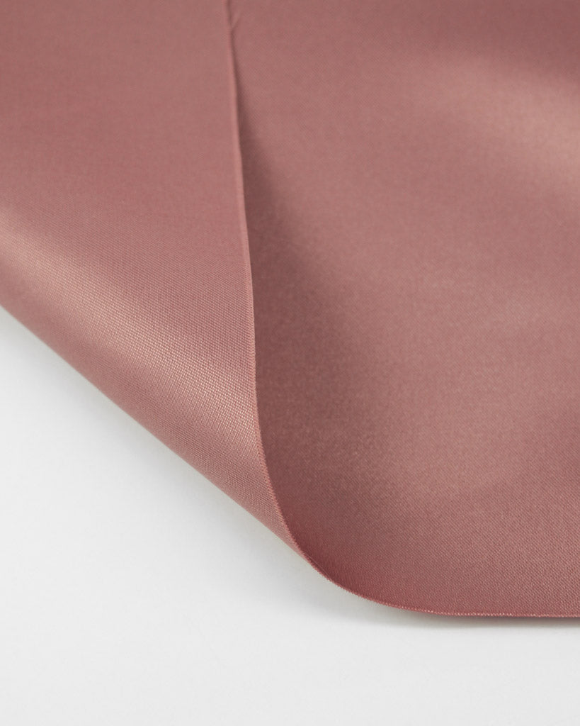 Close-up of a pink satin fabric on a white background