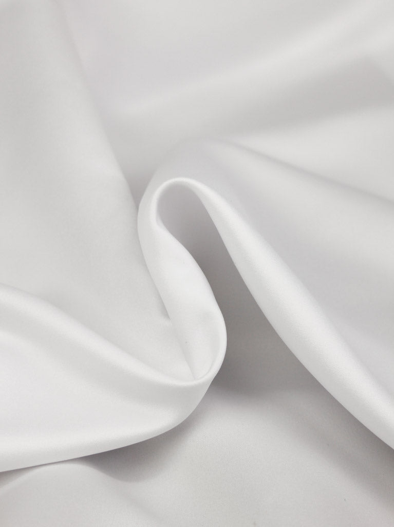Close-up of white satin fabric with a subtle texture