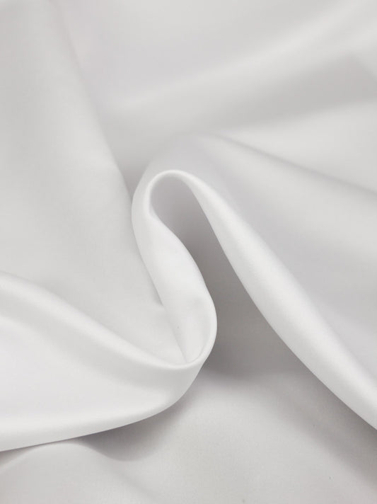 Close-up of white satin fabric with a subtle texture