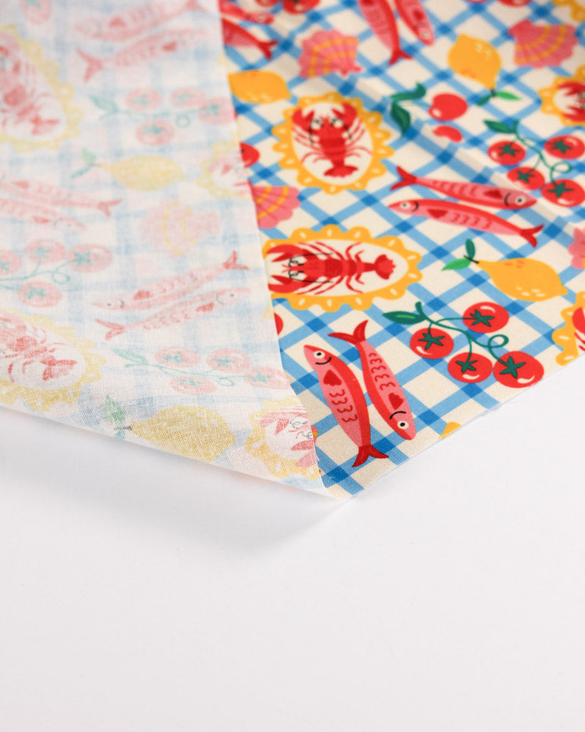 Reverse view of fabric with colourful seafood picnic patterns on a white background