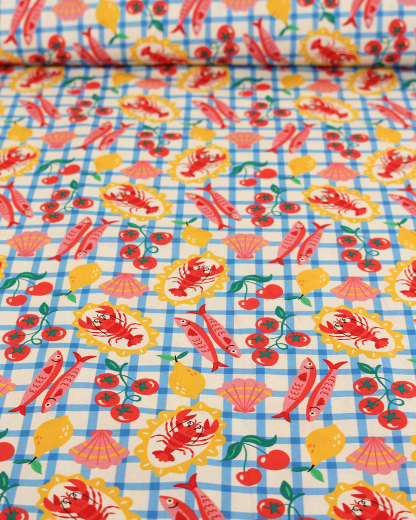 Colourful cotton fabric with lobster, fish, and shell pattern on a blue checkered background