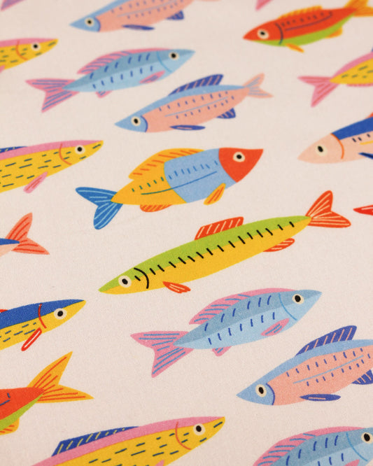 Cotton fabric with rainbow colourful fish repeat pattern on a white background