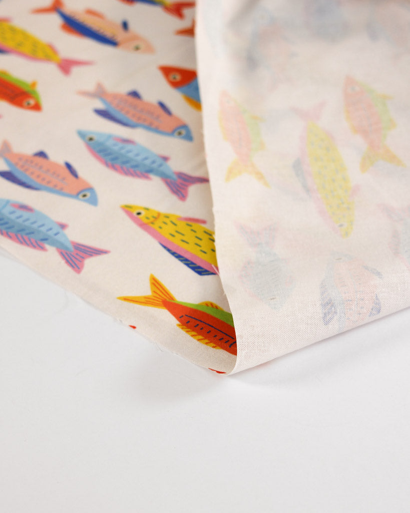 Cotton fabric with colourful rainbow fish pattern on a white background