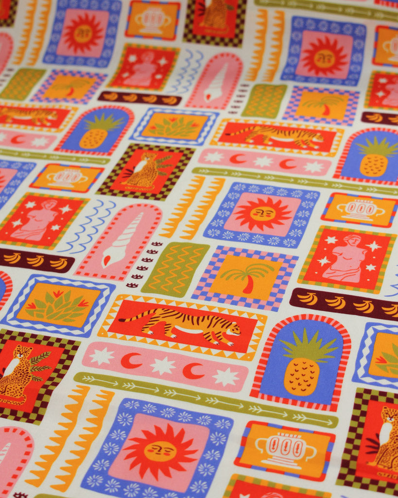 Colourful viscose fabric with a fun tile pattern featuring illustrations of tigers, seashells, suns, palm trees, fruit, pineapples, bananas and tropical imagery