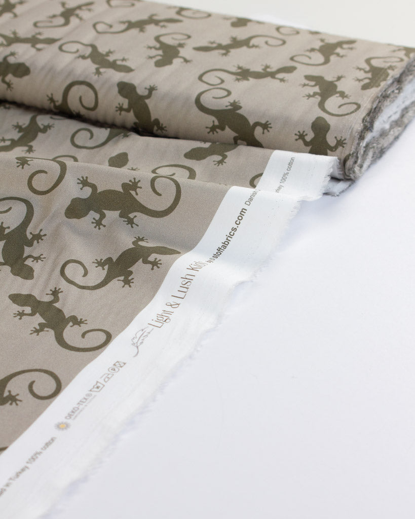 Cotton lawn fabric with green lizard pattern on beige background