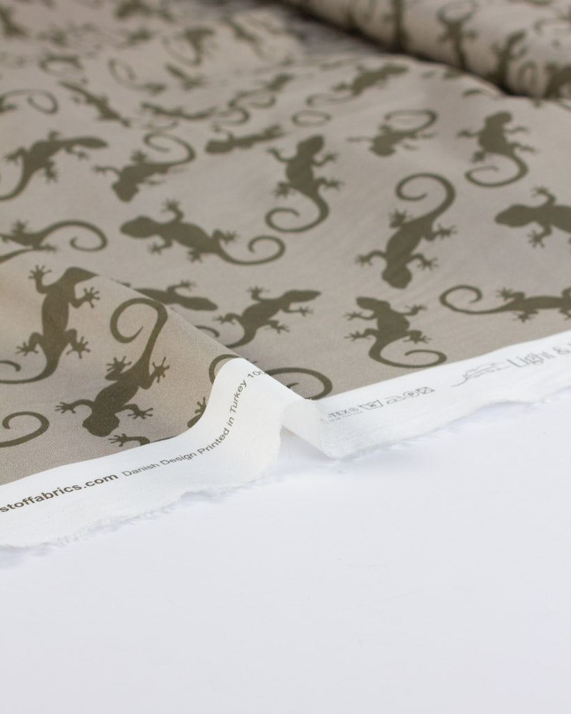 Cotton lawn fabric with gecko lizard pattern on a beige background