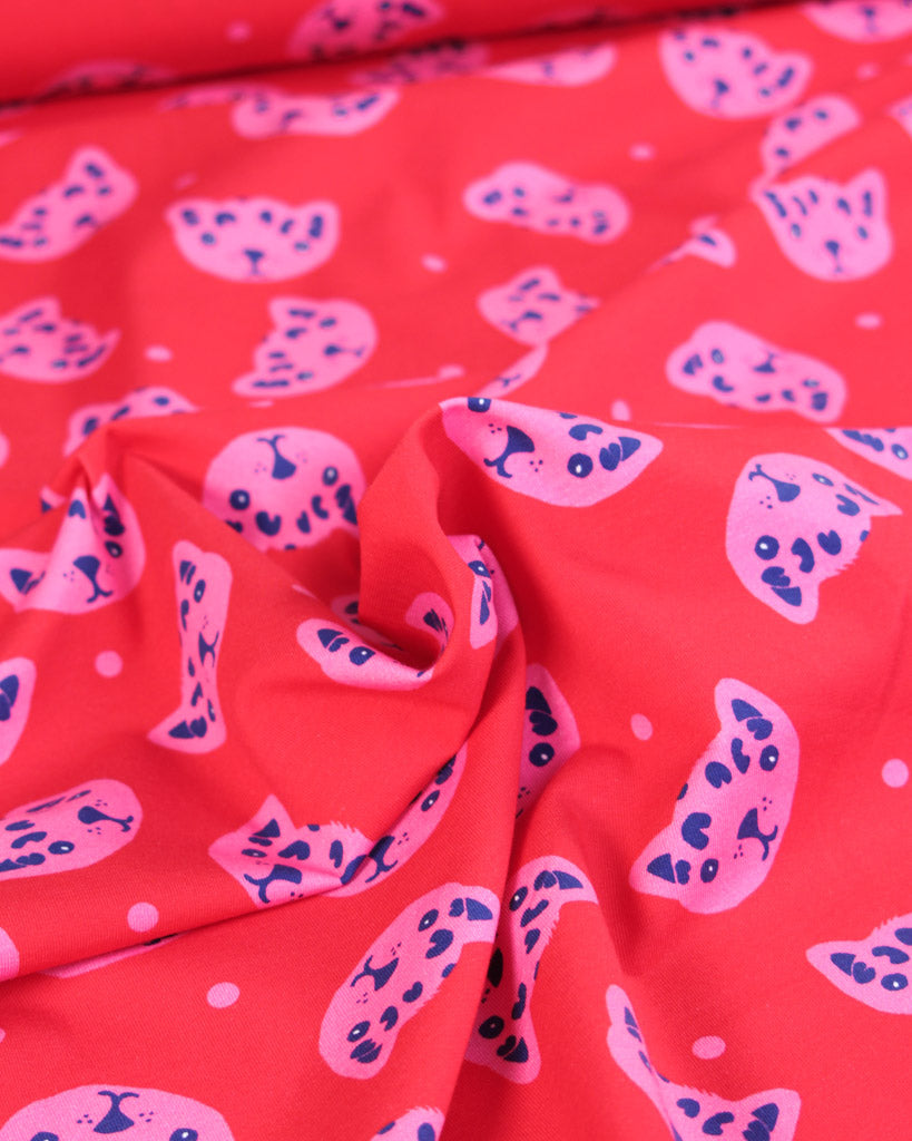 Red jersey fabric with pink and blue cat pattern