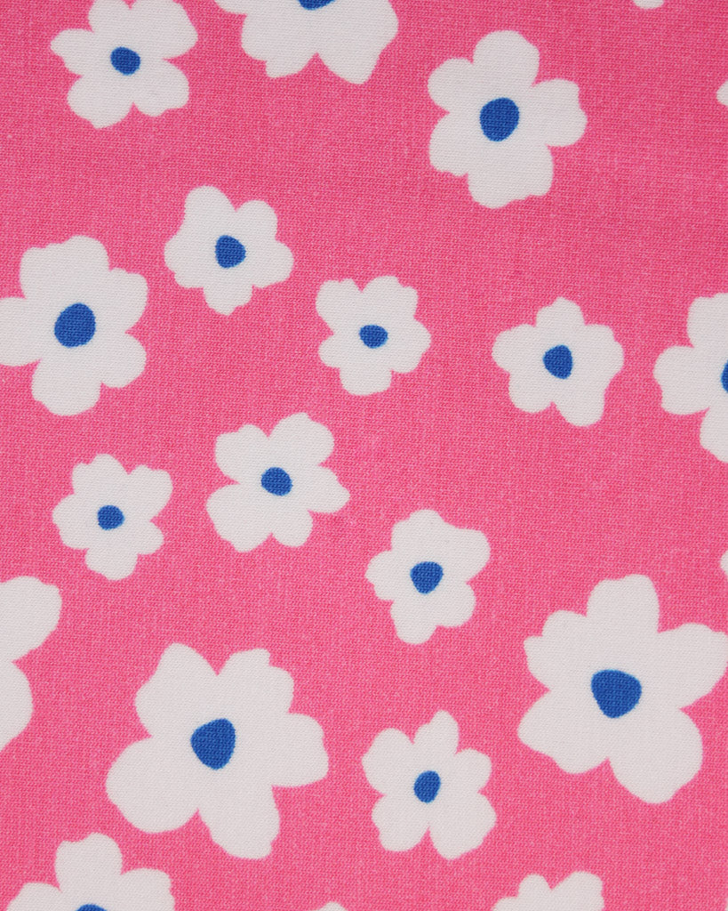 Pattern of white flowers with blue centers on a pink background on cotton jersey fabric
