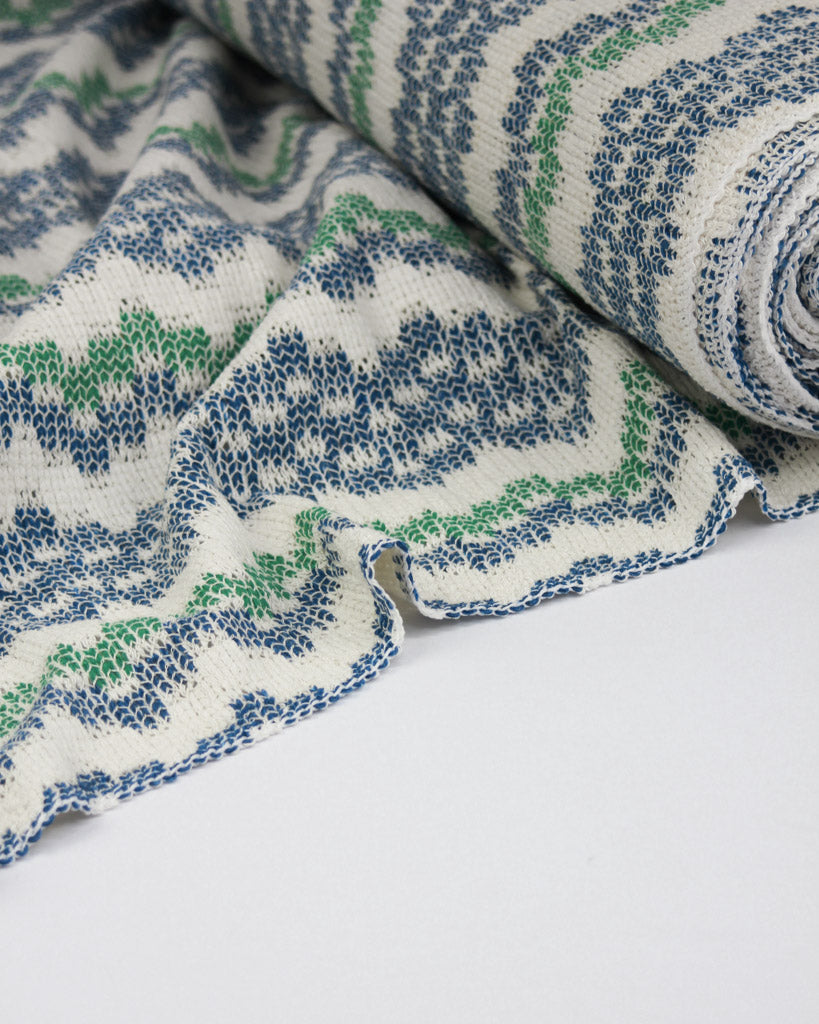 Close-up of patterned fabric with blue and green design on a white background