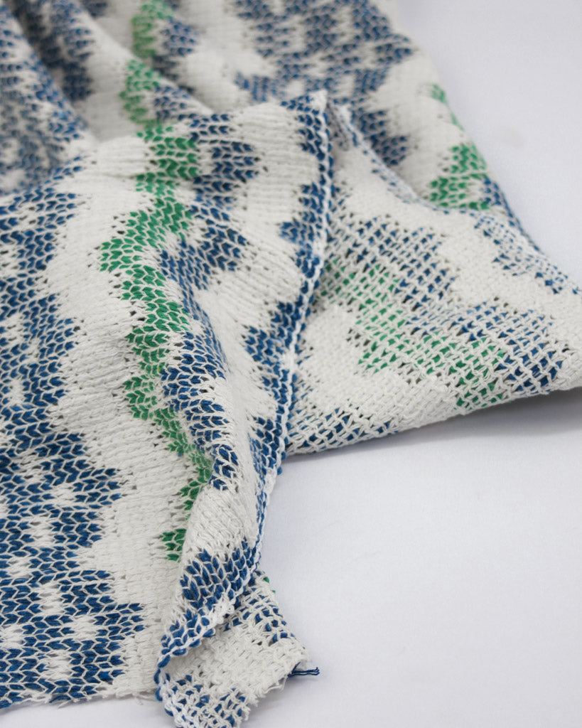 Knitted fabric with blue and green pattern on a white background