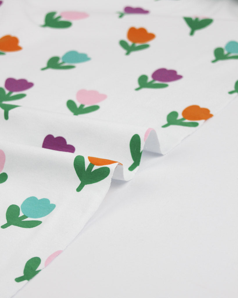 Colourful tulip floral pattern on a white fabric background on cotton jersey fabric